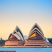 australia stock photography | Sydney Opera House at Sunrise, Kirribilli, Sydney, New South Wales (NSW), Australia, Image ID AU-SYDNEY-OPERA-HOUSE-0047. The Sydney Opera House stands majestically against a brilliant sunrise, bathed in a warm, golden light. The iconic sails of the building glow softly as the first rays of the day touch the harbour, casting a serene reflection on the water below. The vibrant sky hues blend seamlessly with the elegant curves of the Opera House, creating a captivating harmony of nature and architecture as Sydney awakens.